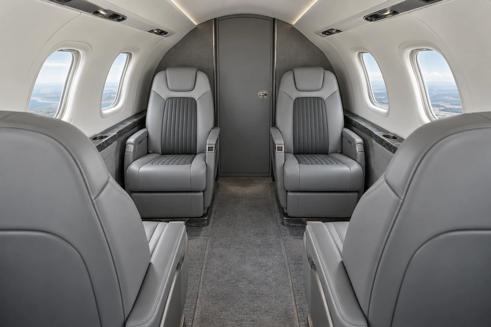 Honda HA-420 cabin interior illustration: representative HondaJet Elite II cabin looking aft at four club chairs; fifth lounge chair is behind the camera. Actual interiors vary.